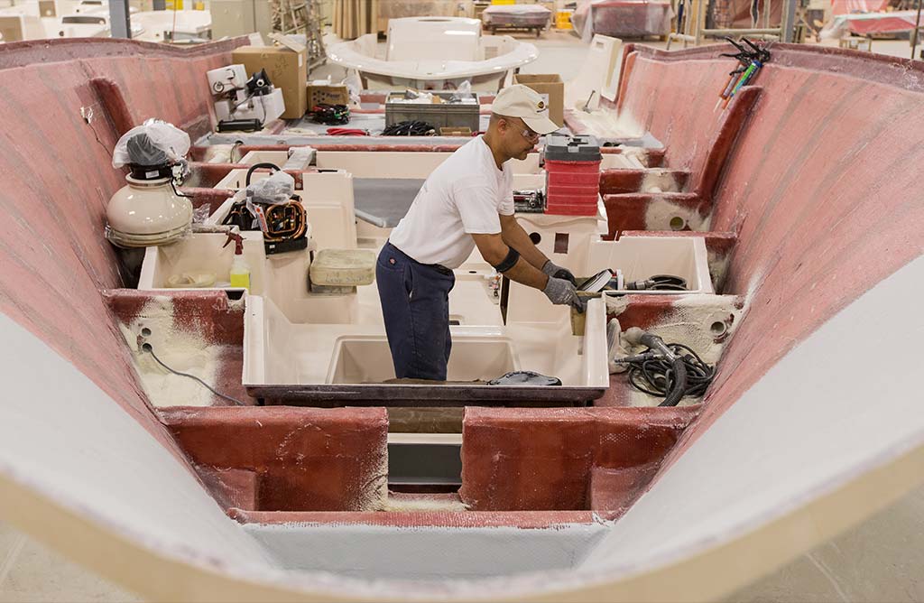 A man working inside the hull of a Grady-White boat during the building process