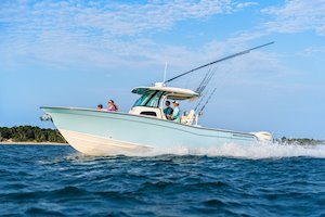 Grady-White Canyon 306 30-foot center console running with wooded beach in background