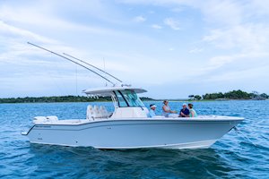 Grady-White Canyon 326 32-foot center console cruising starboard side with people eating in bow