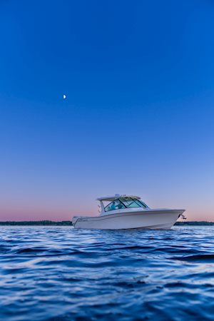 Grady-White Freedom 345 dual console boat on the water starboard side at sunset with moon showing in sky