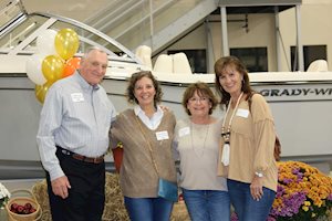 Four people posing in front of a Grady-White boat