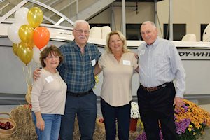 Four people posing with balloons