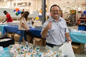Man giving the thumbs up in front of party table